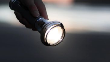 มือคนกำลังถือไฟฉาย